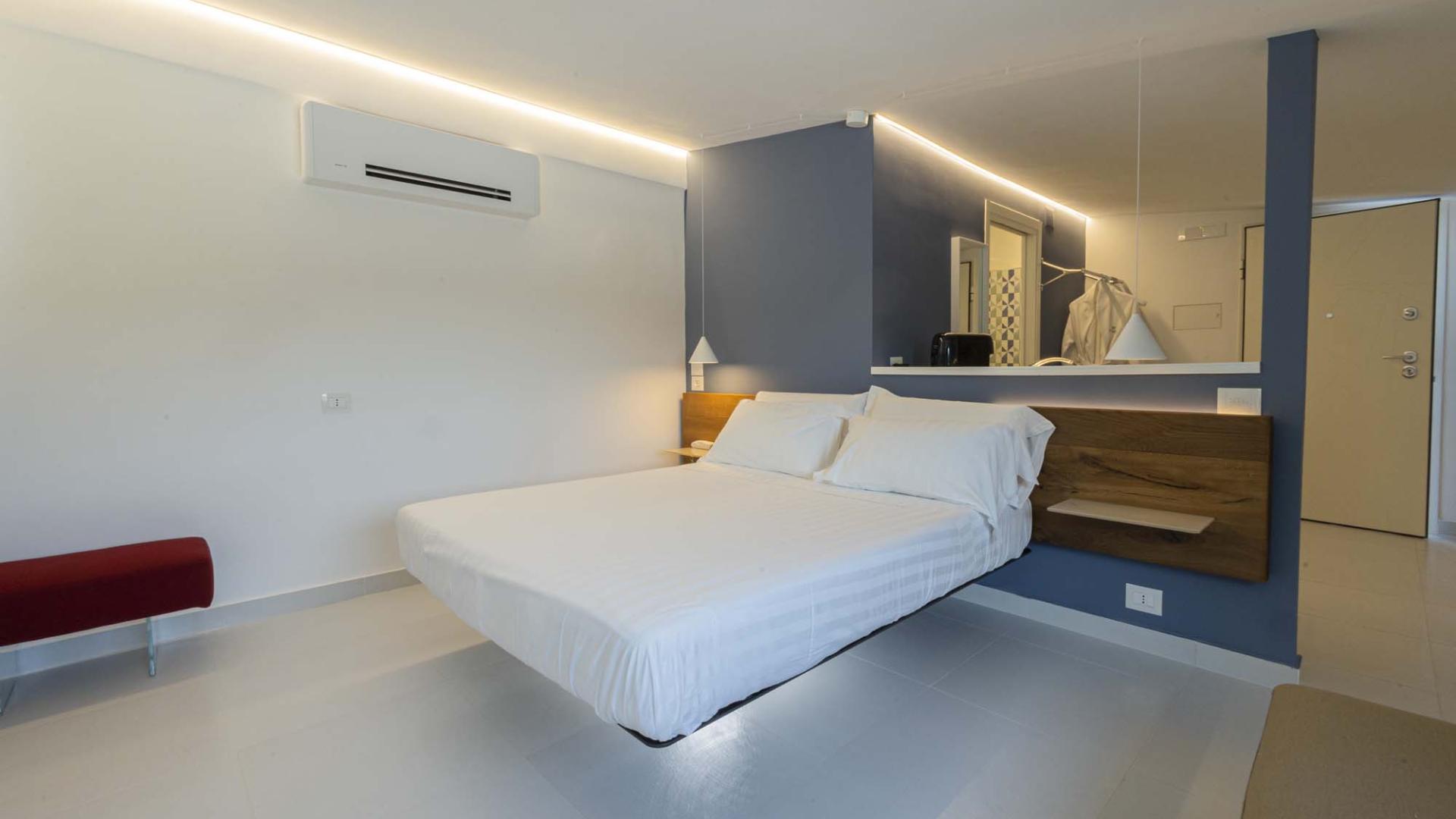 Camera moderna e luminosa con letto sospeso, atmosfera rilassante e minimalista.